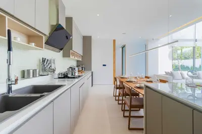 a kitchen with a long counter and a long table at V271 Smart Villa Full Amenities Best Stay Escape in Thalang