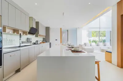 a kitchen with white cabinets and a living room at V271 Smart Villa Full Amenities Best Stay Escape in Thalang