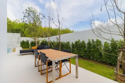 a patio with a wooden table and chairs at V271 Smart Villa Full Amenities Best Stay Escape in Thalang