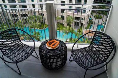 two chairs and a table on a balcony with a pool at Amazing 1Bdr Title Legendary Bang Tao in Bang Tao Beach