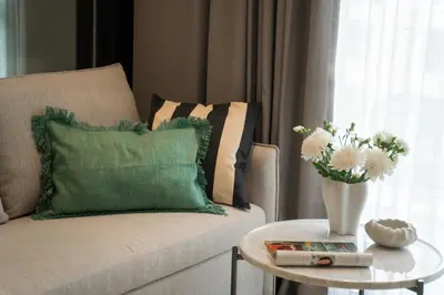 a living room with a couch and a table with a vase of flowers at Amazing 1Bdr Title Legendary Bang Tao in Bang Tao Beach