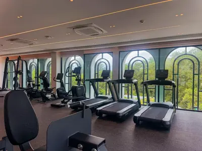 a gym with treadmills and ellipticals in a room with windows at Amazing 1Bdr Title Legendary Bang Tao in Bang Tao Beach