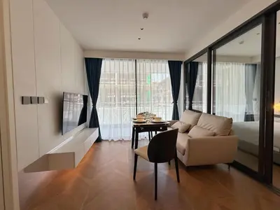 a bedroom with a bed and a couch and a table at Sunshine BEACH FRONT in Layan Beach