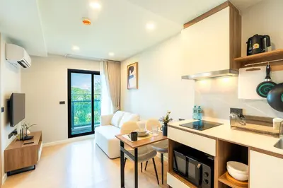 a kitchen and living room with a couch and a table at 1BR near Laguna, Space Cherngtalay, Bangtao beach by Pat in Ban Thalat Choeng Thale