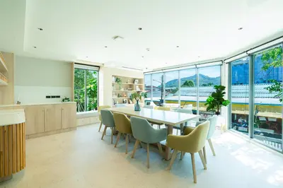 a dining room with a table and chairs and windows at 1BR near Laguna, Space Cherngtalay, Bangtao beach by Pat in Ban Thalat Choeng Thale