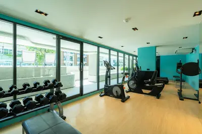 a gym with treadmills and ellipticals and windows at 1BR near Laguna, Space Cherngtalay, Bangtao beach by Pat in Ban Thalat Choeng Thale