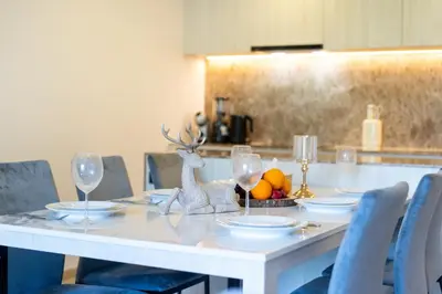 a white table with glasses and a bowl of fruit at Phuket Family apartment in Phuket Town