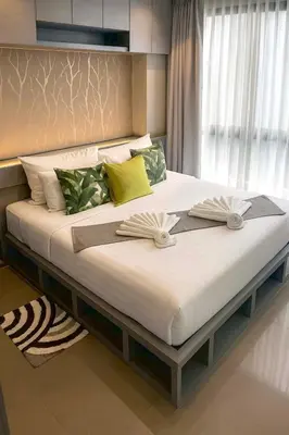 a bedroom with a large bed with two books on it at The Kamala View in Kamala Beach