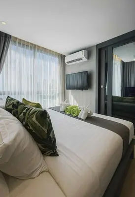 a large white bed in a room with a window at The Kamala View in Kamala Beach