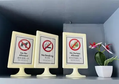 three framed signs on a shelf with a plant at The Kamala View in Kamala Beach