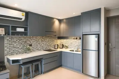 a kitchen with blue cabinets and a stainless steel refrigerator at The Kamala View in Kamala Beach