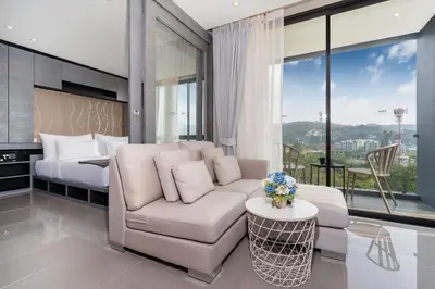 a living room with a couch and a bed at 1BR Mountain View Condo Citygate P708 in Kamala Beach