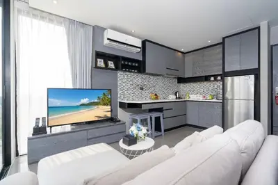a living room with a white couch and a flat screen tv at 1BR Mountain View Condo Citygate P708 in Kamala Beach
