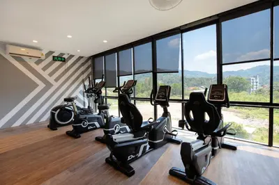 a gym with cardio machines in a room with windows at 1BR Mountain View Condo Citygate P708 in Kamala Beach