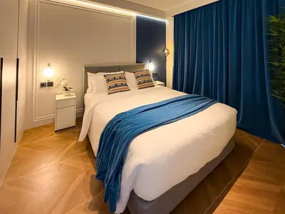 a bedroom with a large bed with blue curtains at Sunshine Layan Beach Resort 2 bedroom #84192 in Layan Beach