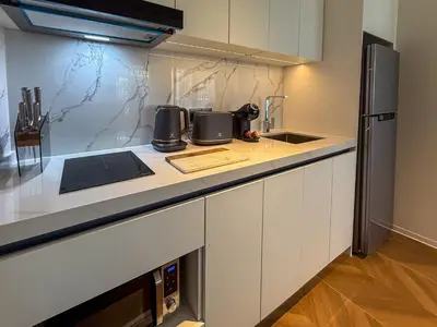 a kitchen with white cabinets and a refrigerator at Sunshine Layan Beach Resort 2 bedroom #84192 in Layan Beach