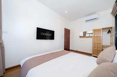 a bedroom with a bed and a tv on the wall at Holistic Haven Private Pool Villa at Kamala Newest Residence in Kamala Beach