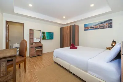 a bedroom with a large white bed and a desk at Villa Mangosteen 3BR Seaview Pool and Rooftop in Ban Saiyuan (1)