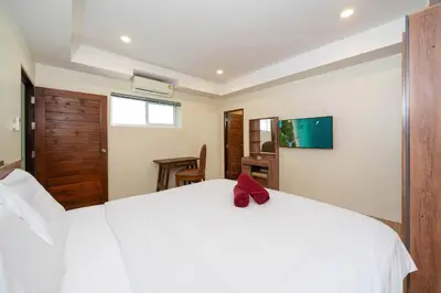 a bedroom with a white bed with a red bow on it at Villa Mangosteen 3BR Seaview Pool and Rooftop in Ban Saiyuan (1)