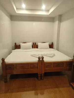 a large bed with white sheets and pillows on it at OYO Dynasty Hotel in Patong Beach