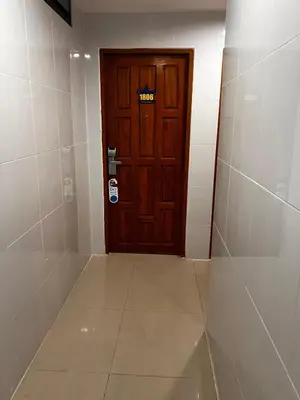 a room with a wooden door and a tiled floor at OYO Dynasty Hotel in Patong Beach