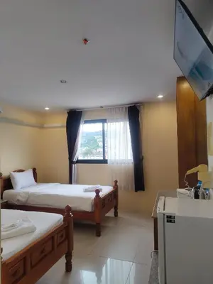 a hotel room with two beds and a television at OYO Dynasty Hotel in Patong Beach