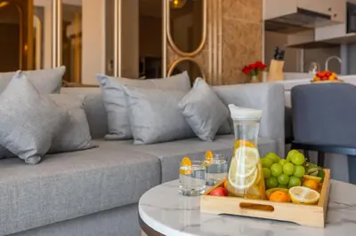a tray of fruit on a table next to a couch at Suite Ostia with Gym Pool Access-Bellevue Lagoon in Laguna Phuket