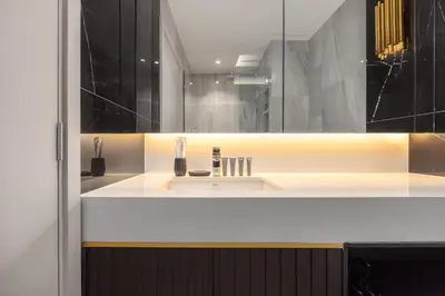 a bathroom with a white sink and a mirror at Suite Ostia with Gym Pool Access-Bellevue Lagoon in Laguna Phuket