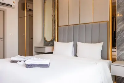 a bedroom with a large white bed with towels on it at Suite Ostia with Gym Pool Access-Bellevue Lagoon in Laguna Phuket