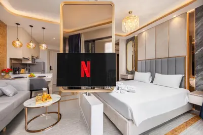 a bedroom with a television with the letter n on it at Suite Imola Gym Pool Close to Beach – Bellevue in Laguna Phuket