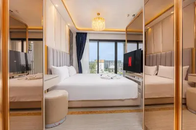 a hotel room with two beds and a mirror at Suite Imola Gym Pool Close to Beach – Bellevue in Laguna Phuket