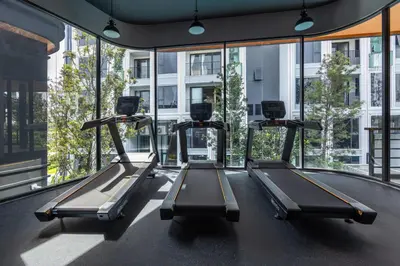 a gym with three treadmills in a building at Suite Imola Gym Pool Close to Beach – Bellevue in Laguna Phuket