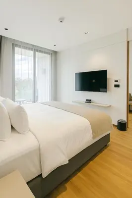 a white bedroom with a large bed and a flat screen tv at Layan Green Park by Search Estate 1 bedroom in Ban Nong Chaeng