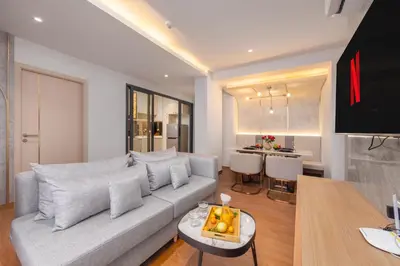 a living room with a couch and a table at Suite Avila 2BR Gym Pool Close to Beach in Laguna Phuket
