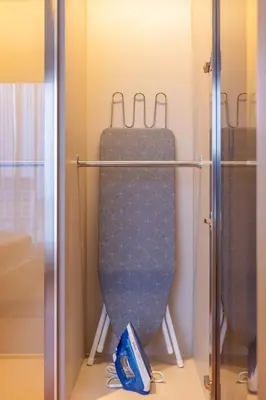 a suitcase is on a rack in a closet at Suite Avila 2BR Gym Pool Close to Beach in Laguna Phuket