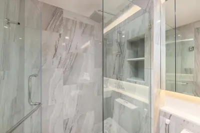 a bathroom with a shower with a glass door at Suite Avila 2BR Gym Pool Close to Beach in Laguna Phuket