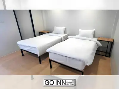 two beds with white sheets in a room at XX GO INN Seng Ho Phuket - โอลทาวน์ Oldtown in Phuket Town
