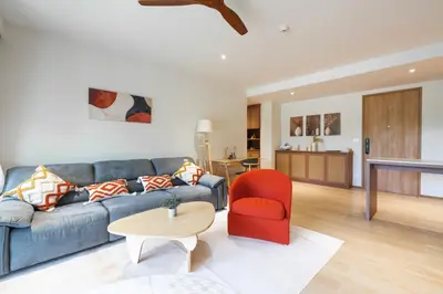 a living room with a blue couch and a red chair at Beachside Residences 3 BR apartment by NLA in Bang Tao Beach