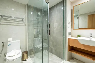 a bathroom with a shower and a toilet and a sink at Beachside Residences 3 BR apartment by NLA in Bang Tao Beach