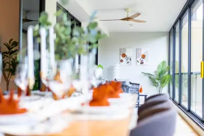 a dining room with tables and chairs and windows at Beachside Residences 3 BR apartment by NLA in Bang Tao Beach