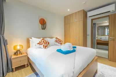 a bedroom with a white bed with a blue tray on it at Beachside Residences 3 BR apartment by NLA in Bang Tao Beach