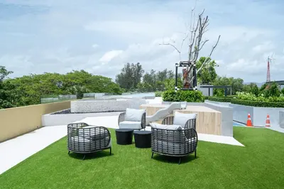a patio with chairs and a table and grass at Beachside Residences 3 BR apartment by NLA in Bang Tao Beach