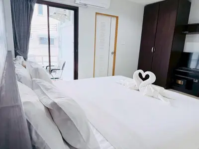 a white bed with a heart ribbon on it at The Sense in Patong Beach