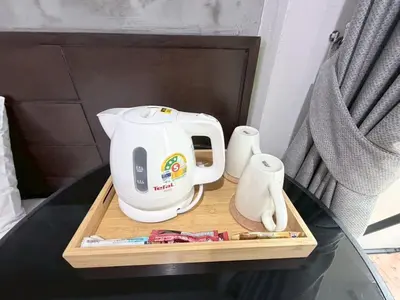 a tea kettle on a wooden tray on a table at The Sense in Patong Beach