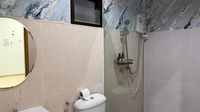 a bathroom with a shower and a toilet and a mirror at The Sense in Patong Beach
