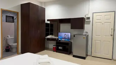 a room with a bathroom with a television and a refrigerator at The Sense in Patong Beach