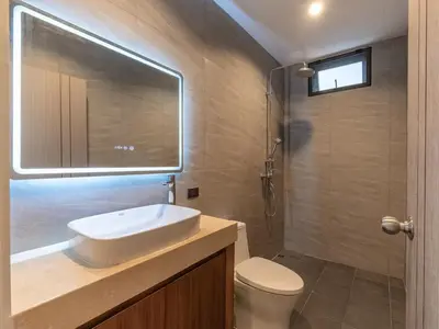 a bathroom with a sink and a toilet and a mirror at Lakeside 5-BR New Pool Villa in Gated Community in Chalong