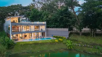 a house with a pond in front of it at Lakeside 5-BR New Pool Villa in Gated Community in Chalong