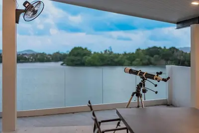a camera on a tripod on a balcony with a view of a lake at Lakeside 5-BR New Pool Villa in Gated Community in Chalong