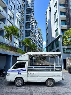 a white van parked in front of tall buildings at Popular Kamala City Gate 1 bdr 3 Pools in Kamala Beach